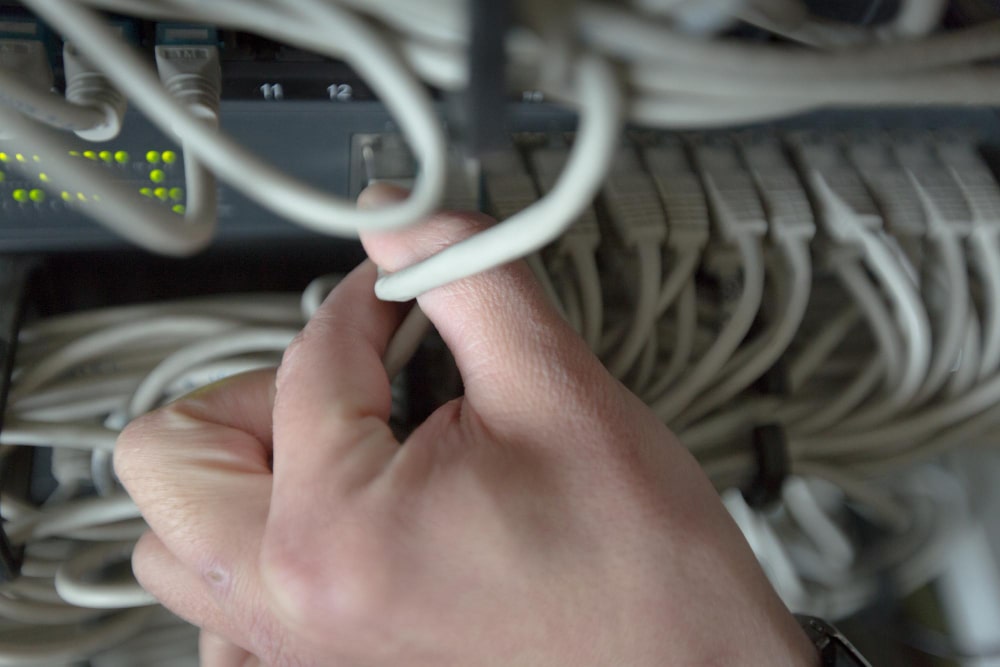 Main branchant un câble Ethernet sur un switch réseau.