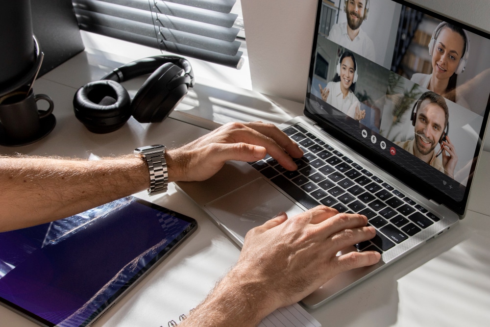 Employé en télétravail participant à une visioconférence sur ordinateur portable, illustrant les enjeux de cybersécurité liés au travail à distance