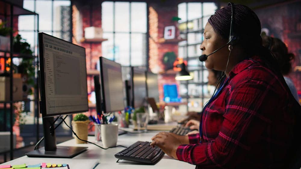 Technicienne du support infogérance traitant une demande depuis son poste